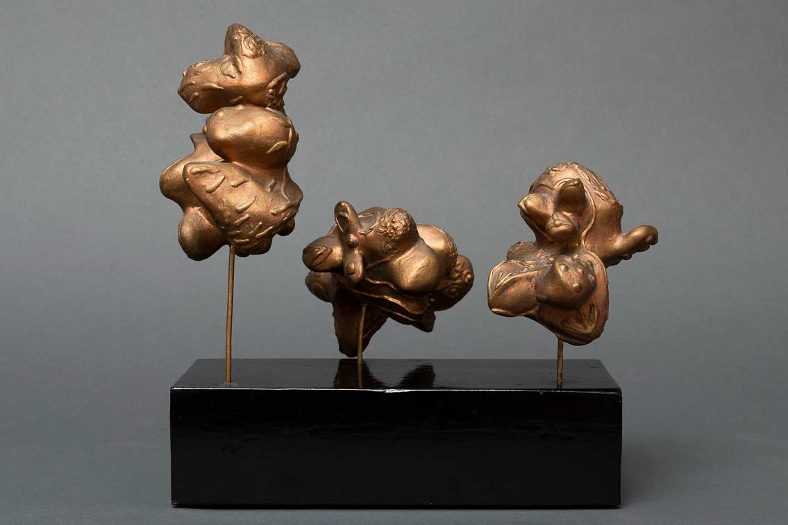 Les trois graces (De tre gratier) 25x12x20, skulptur i acrylpasta, belagt med mørk bladguld. La Bussière 1984   ・・➣ På stilke på sort træsokkel 20x10x5.